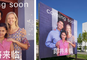 vor dem NS-Dokumentationszentrum steht ein Billboard, auf dem eine multikulturelle Kleinfamilie zu sehen ist Darauf steht oben "Coming soon", darunter vier asiatische Schriftzeichen